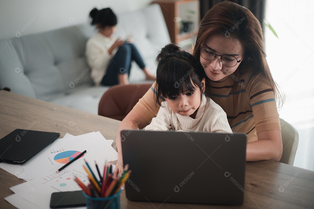 Mãe trabalhando em home-office com filha no colo