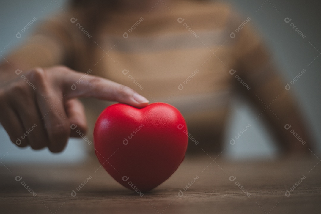 Mãos femininas segurando coração vermelho, dia mundial da saúde mental e mundo