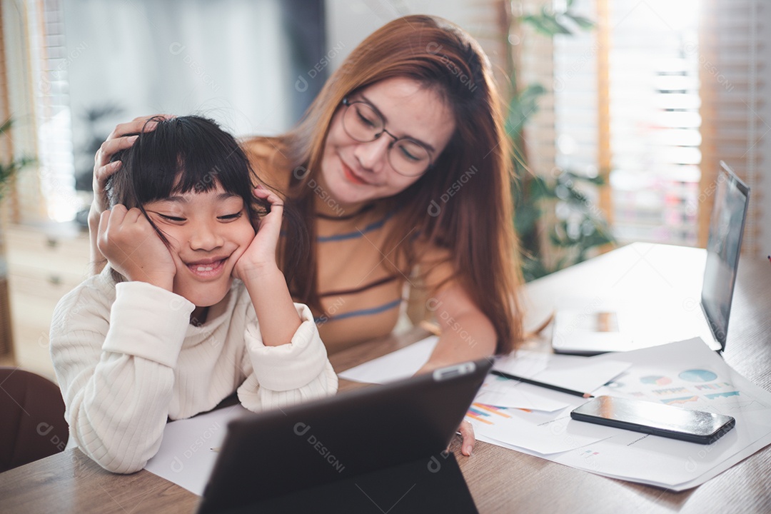 Mãe amorosa, apoiando a filha cansada estudando juntos em casa.