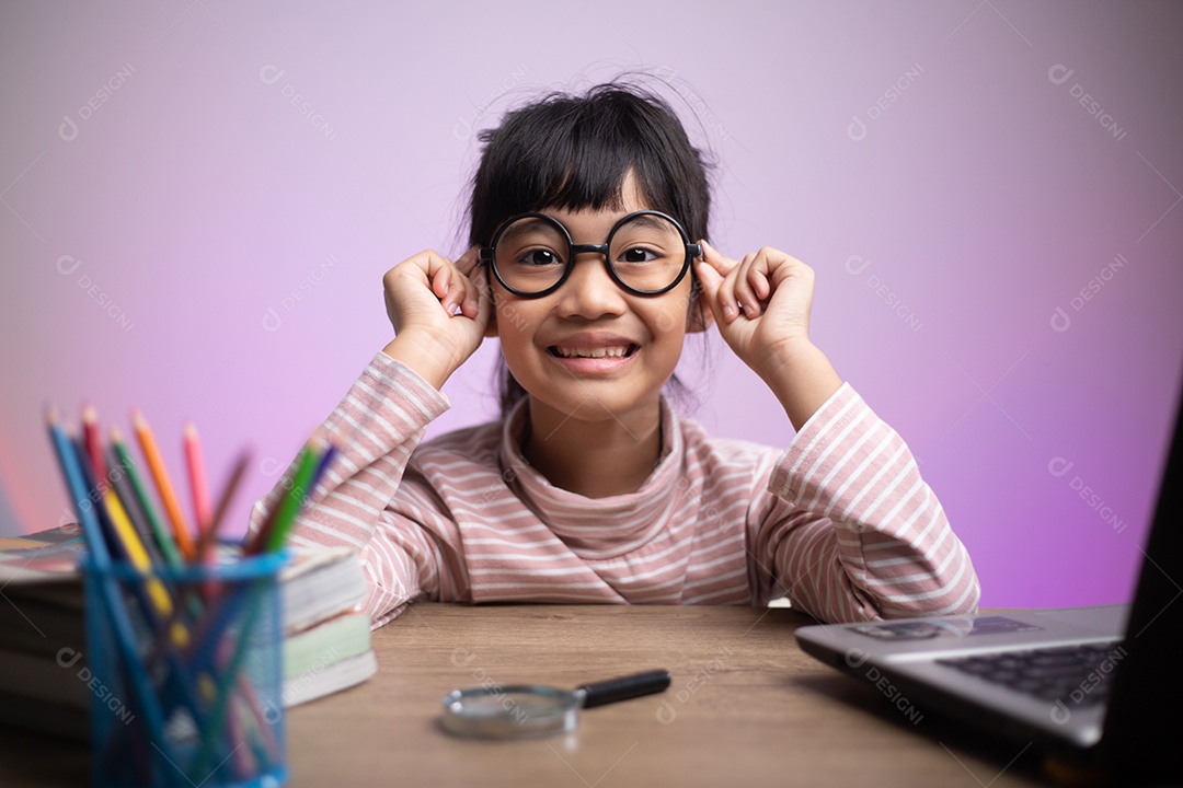 Menina asiática sentada e estudando em casa em um laptop para estudar
