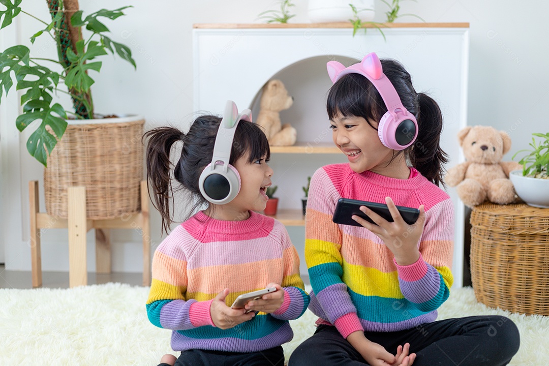 Irmãos meninas ouvindo música com fone de ouvido felizes juntos