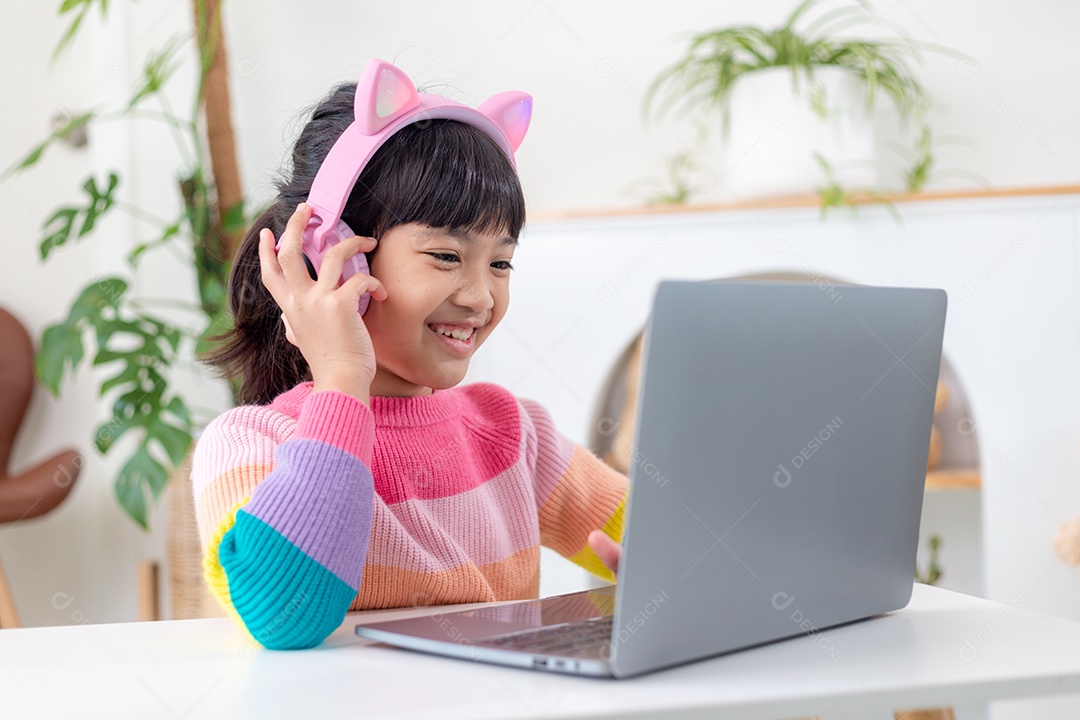 Garotinha asiática sorridente tem uma aula distante de videochamada