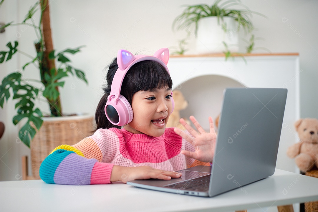 Garotinha asiática sorridente tem uma aula distante de videochamada