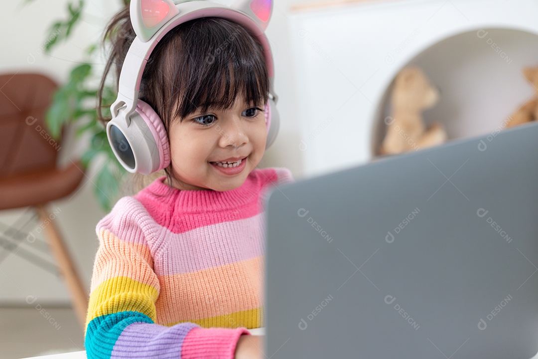 Garotinha asiática sorridente tem uma aula distante de videochamada