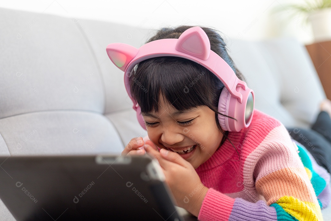 Menina asiática feliz ouvindo música na sala de estar