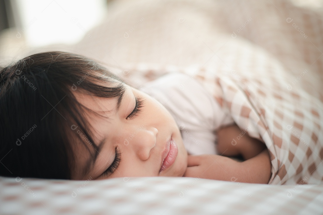 Criança menina dorme na cama com um ursinho de pelúcia de brinquedo