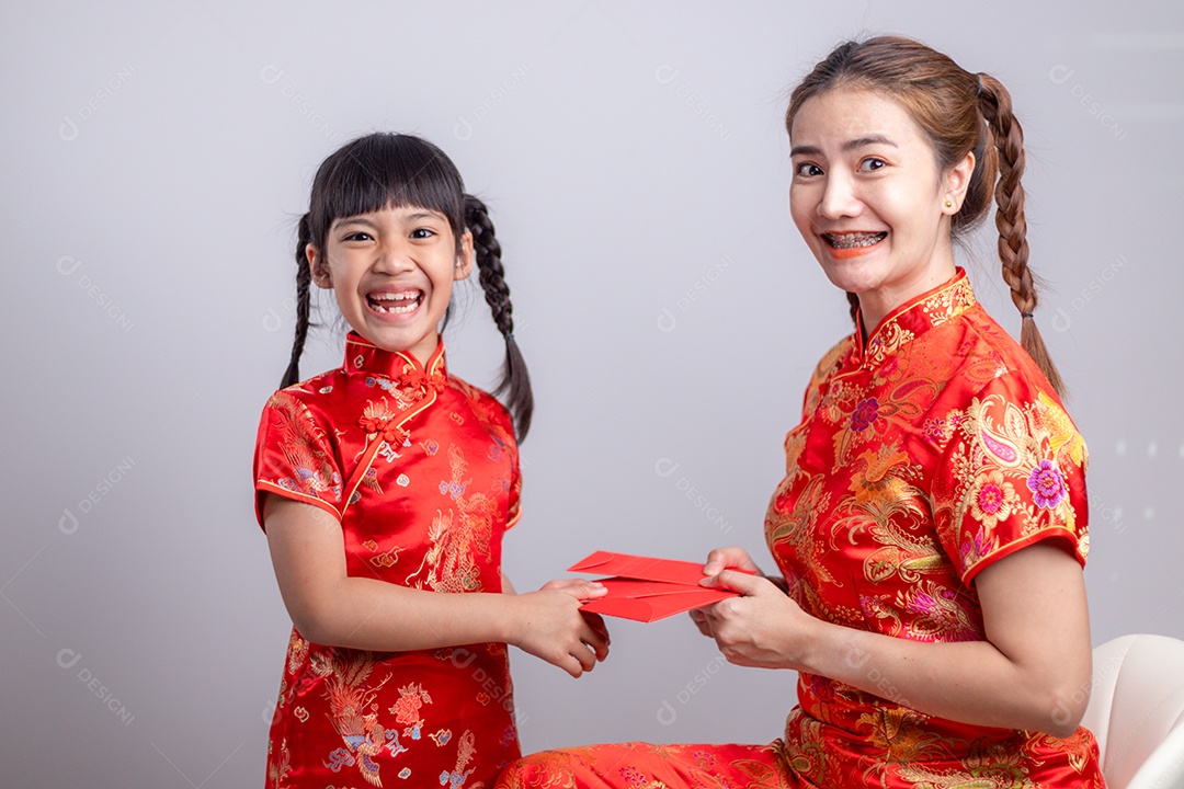 Menina asiática feliz recebeu envelope vermelho da mãe para o ano novo chinês