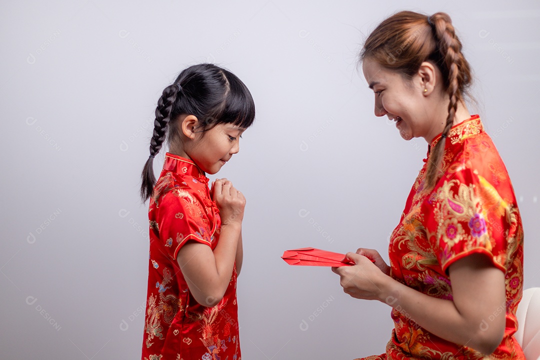 Menina asiática feliz recebeu envelope vermelho da mãe para o ano novo chinês