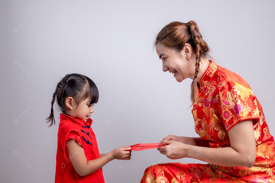 Menina asiática feliz recebeu envelope vermelho da mãe para o ano novo chinês