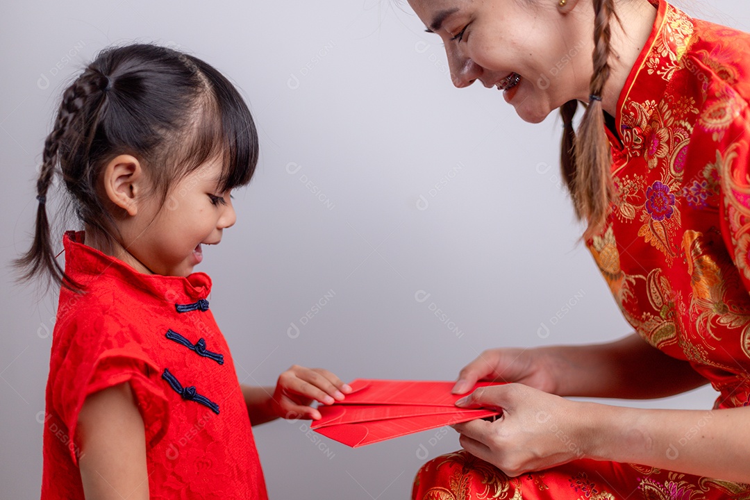 Menina asiática feliz recebeu envelope vermelho da mãe para o ano novo chinês