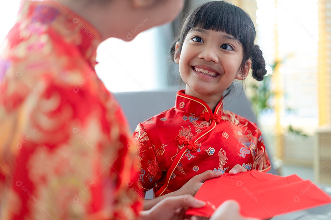 Menina asiática feliz recebeu envelope vermelho da mãe para o ano novo chinês