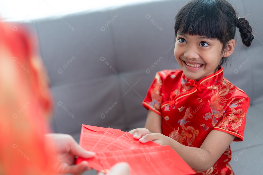 Menina asiática feliz recebeu envelope vermelho da mãe para o ano novo chinês