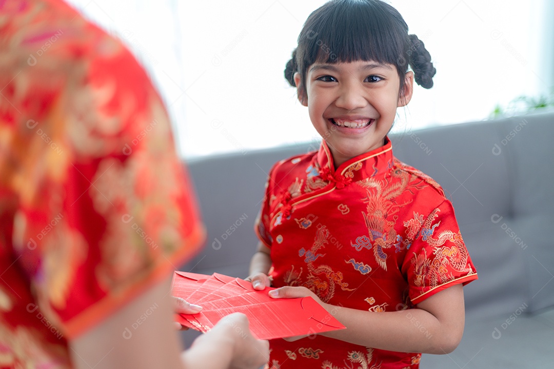 Menina asiática feliz recebeu envelope vermelho da mãe para o ano novo chinês