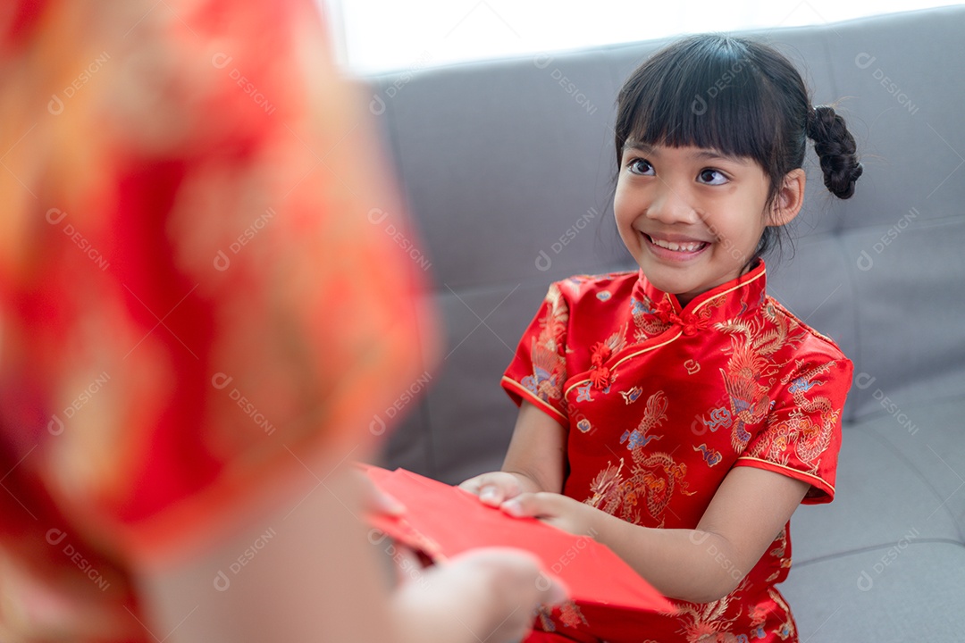Menina asiática feliz recebeu envelope vermelho da mãe para o ano novo chinês