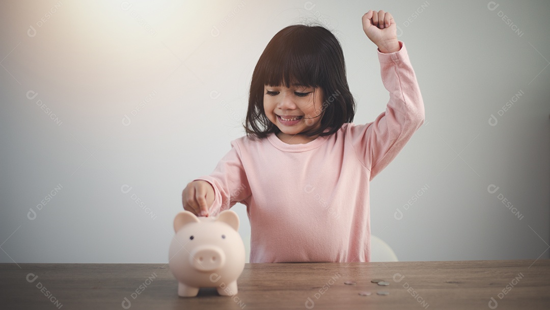 Menina asiática economizando dinheiro em um cofrinho, aprendendo