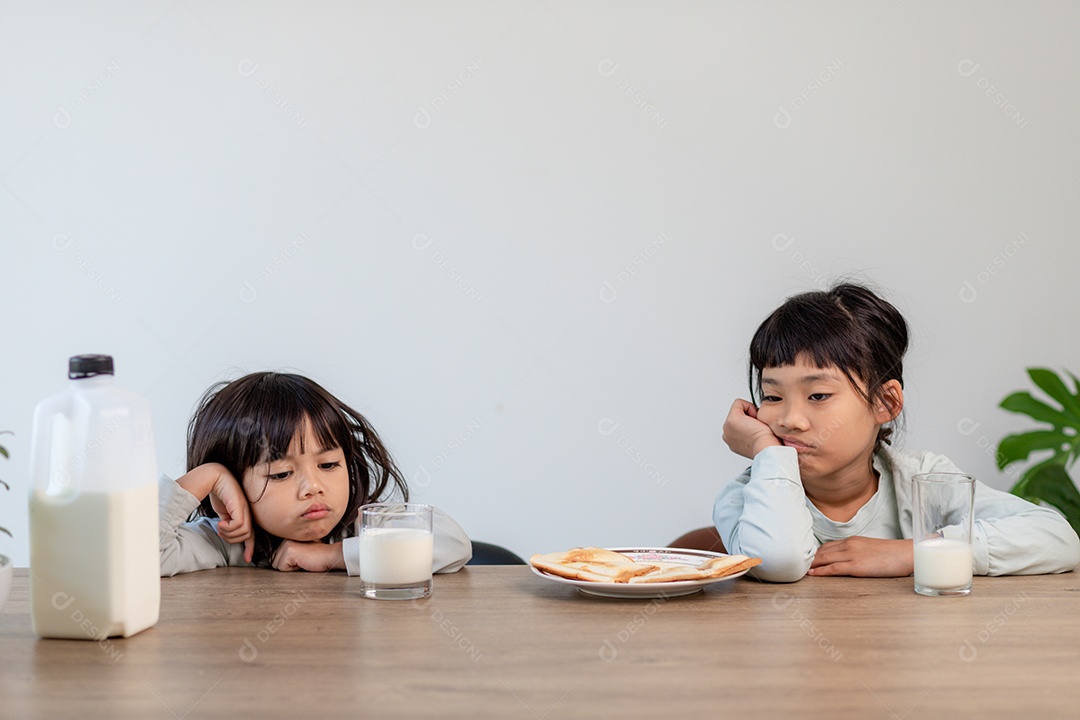 Meninas cansadas do irmão adormeceram no café da manhã