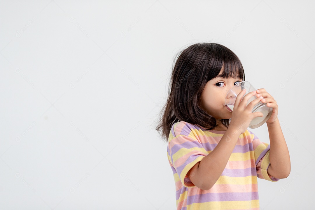 Sorrindo de menina asiática com um copo de leite