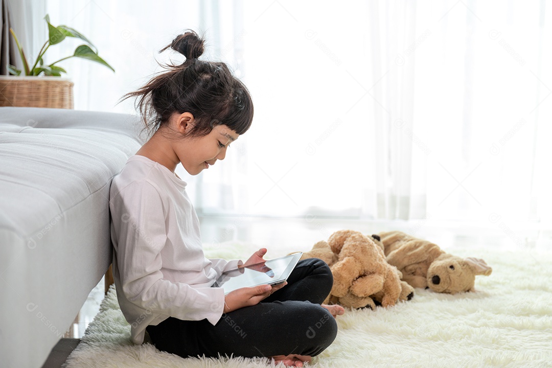 Menina deitada no chão da sala de estar com tablet