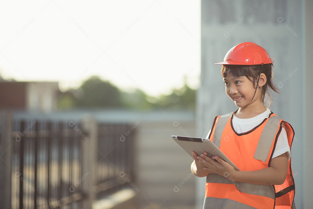 Menina asiática com um capacete de segurança na cabeça e um tablet