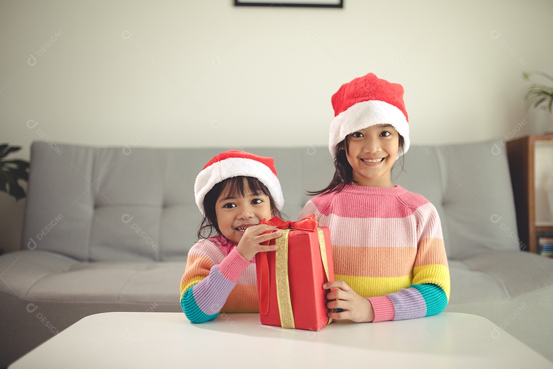 Feliz Natal irmãs felizes com um presente em casa