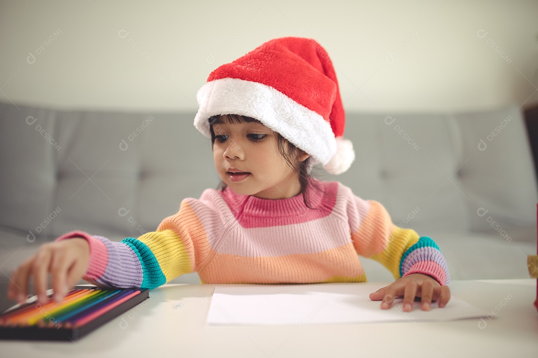 Criança do Natal escreve a carta ao Papai Noel, criança no chapéu de Papai Noel