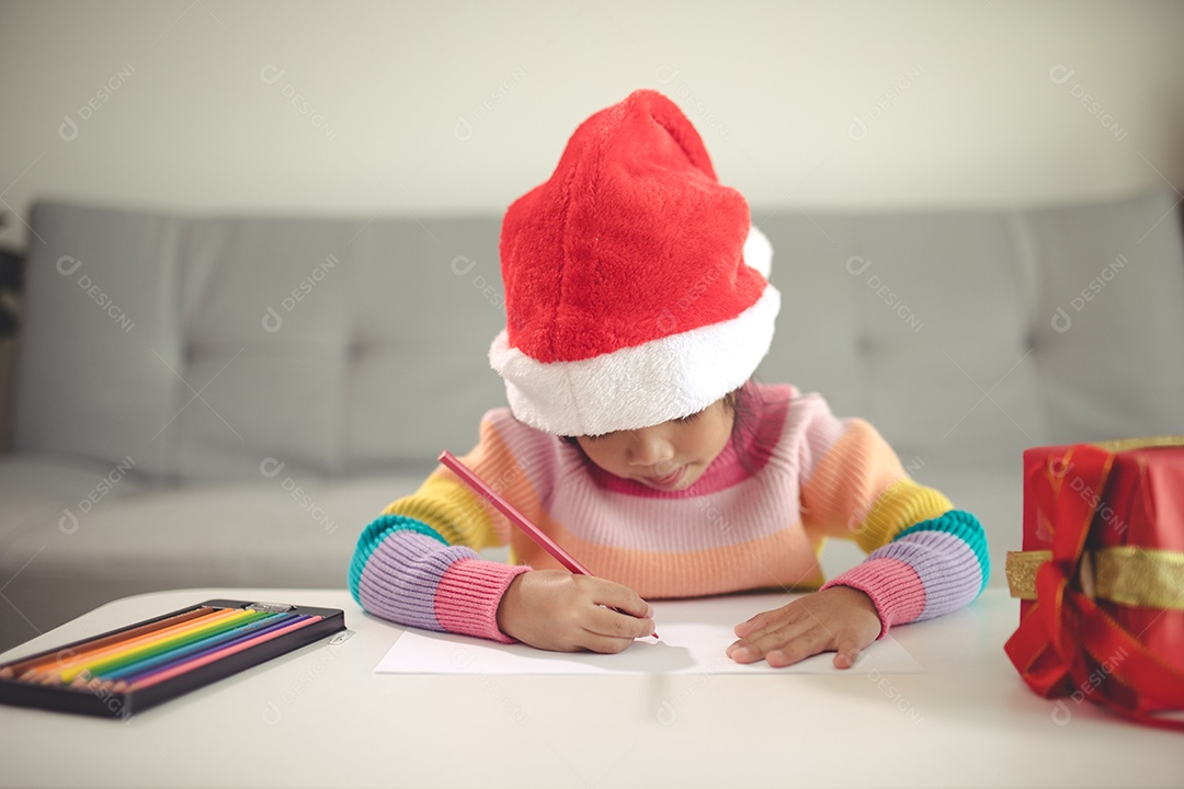 Criança do Natal escreve a carta ao Papai Noel, criança no chapéu de Papai Noel