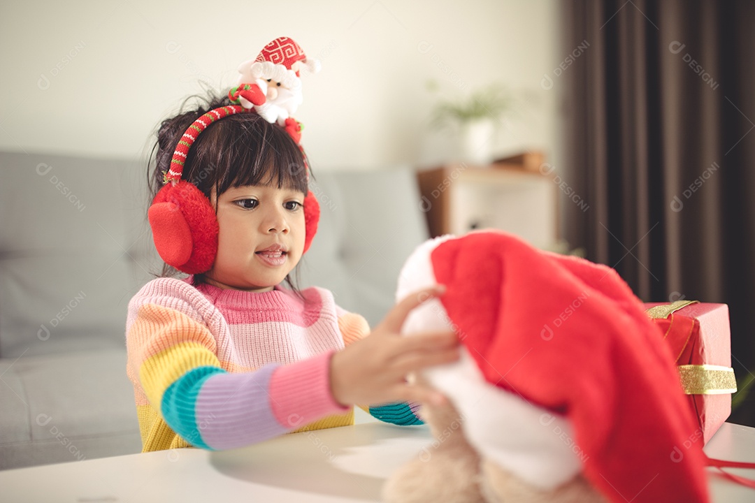 Boas festas Criança bonitinha abrindo presente. A menina gostou do presente.