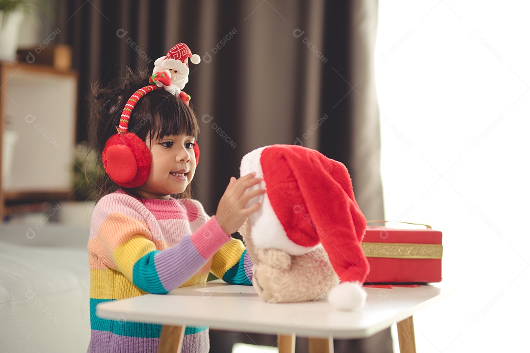 Boas festas Criança bonitinha abrindo presente. A menina gosta