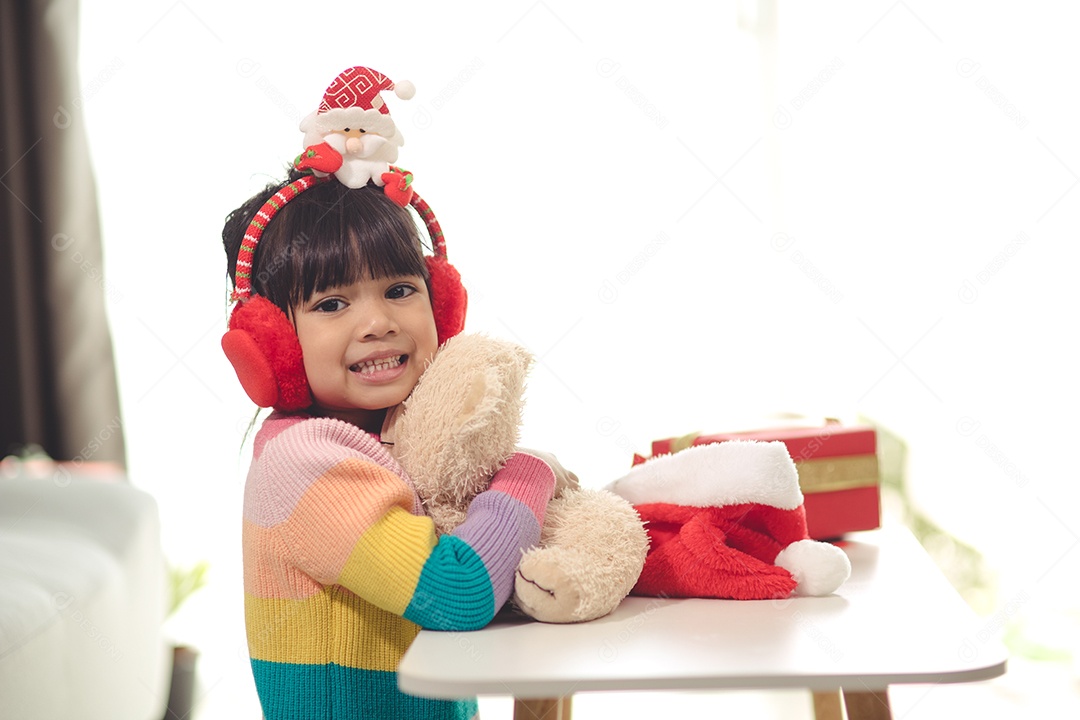 Boas festas Criança bonitinha abrindo presente. A menina gostou do presente.