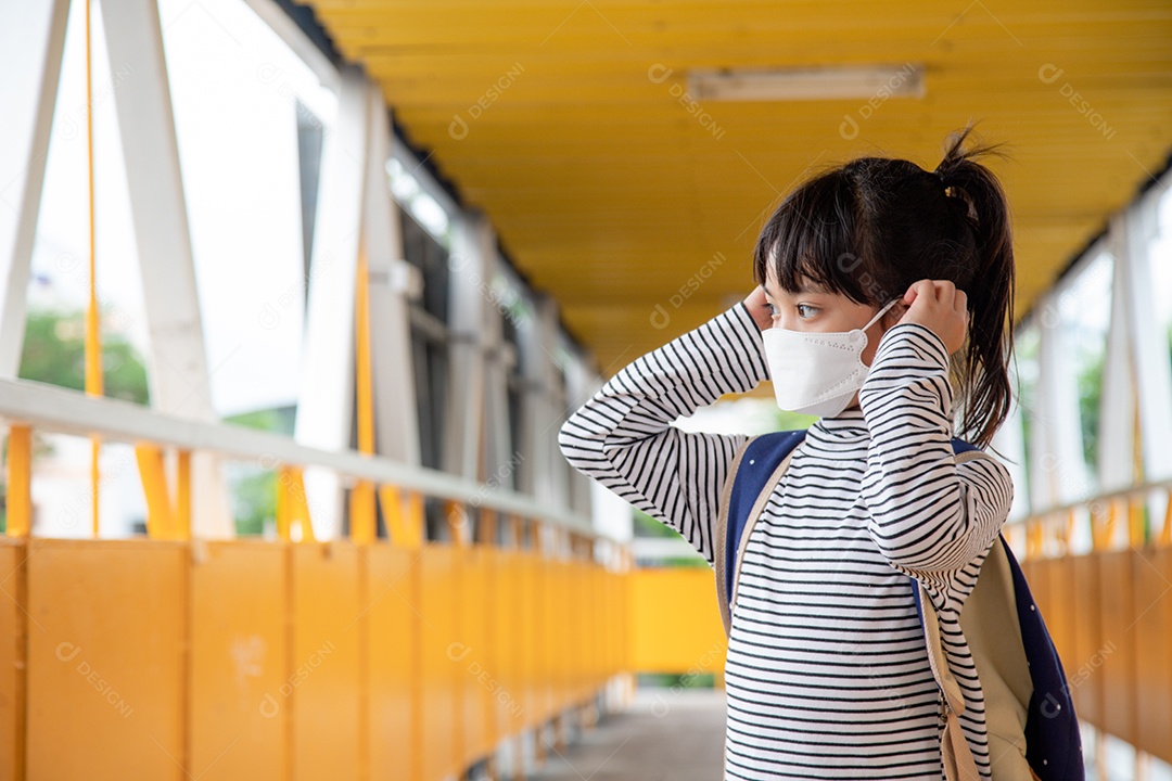 Criança em idade escolar usando uma máscara facial durante o coronavírus e a gripe