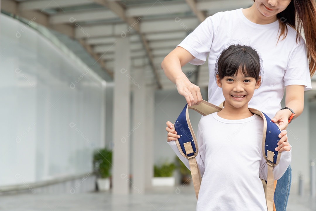 Pai e aluno da escola primária andam de mãos dadas