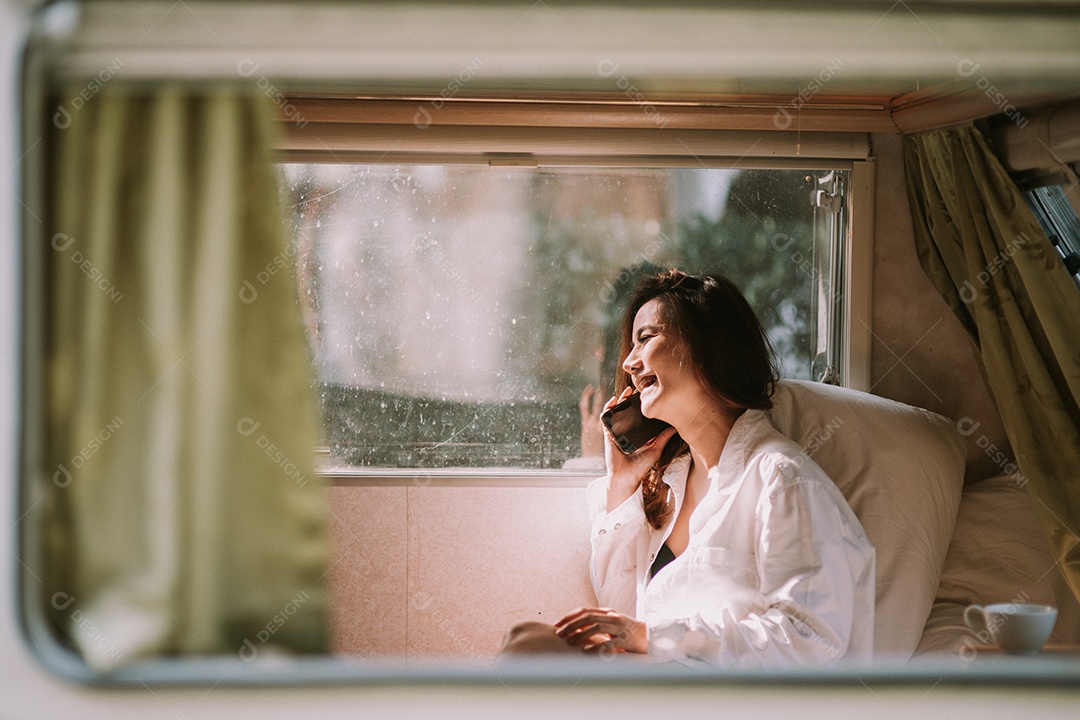 Mulher bonita sexy com um smartphone na cama