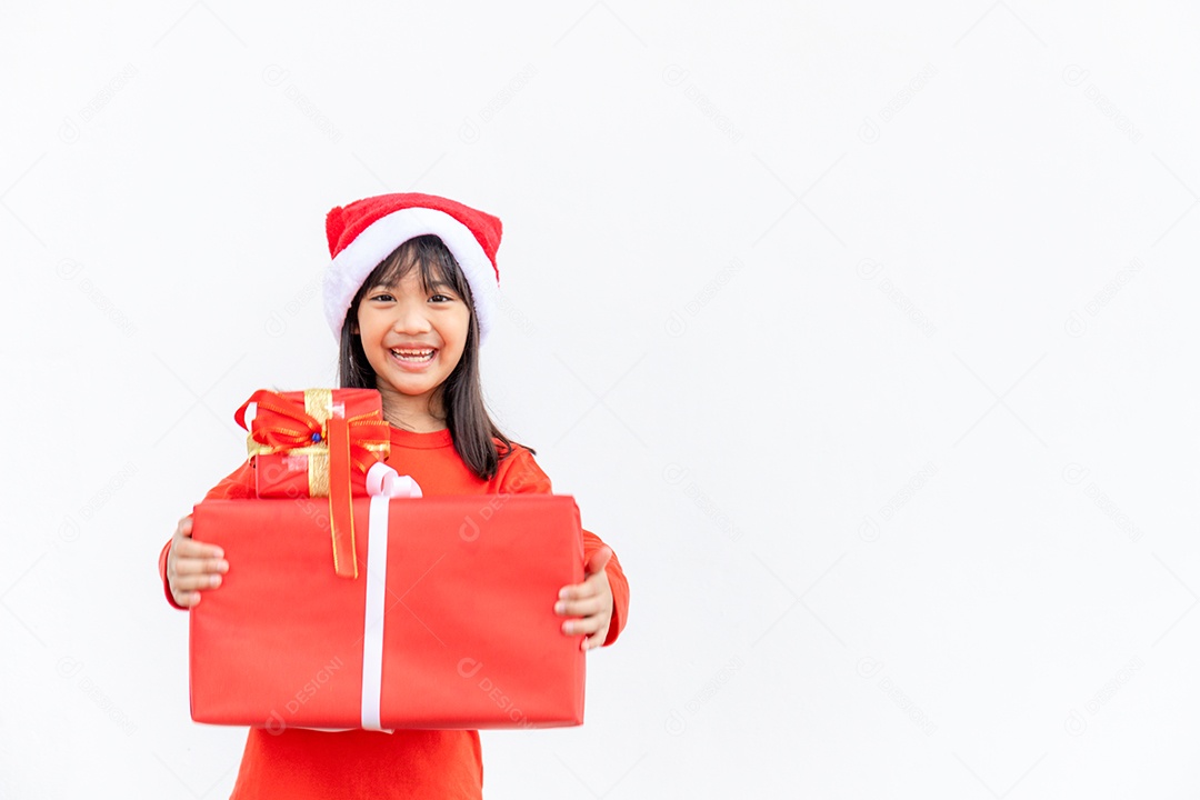 Feliz criança asiática no chapéu vermelho de Papai Noel segurando presentes de Natal