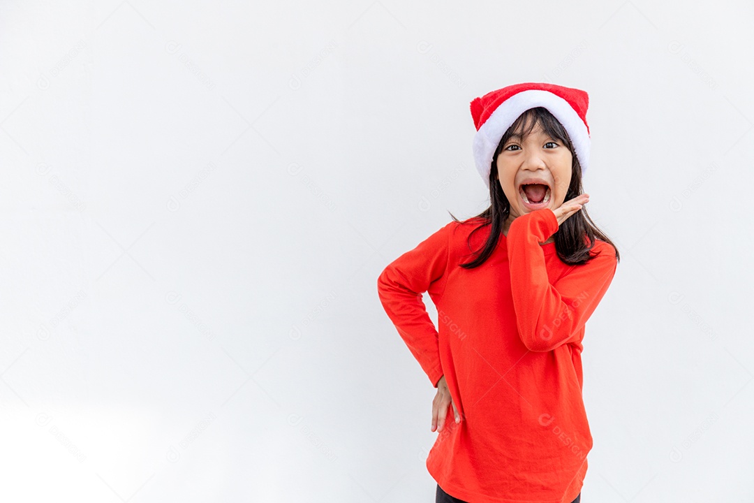 Menina asiática no chapéu de Papai Noel vermelho sobre fundo branco.