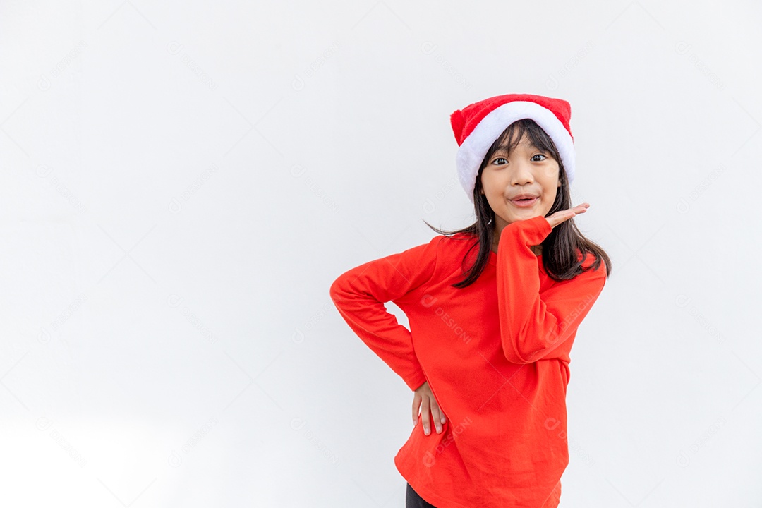 Menina asiática no chapéu de Papai Noel vermelho sobre fundo branco.