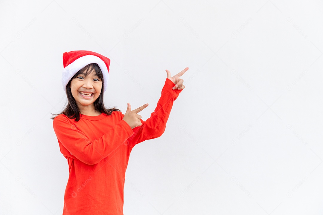 Menina asiática no chapéu de Papai Noel vermelho sobre fundo branco.