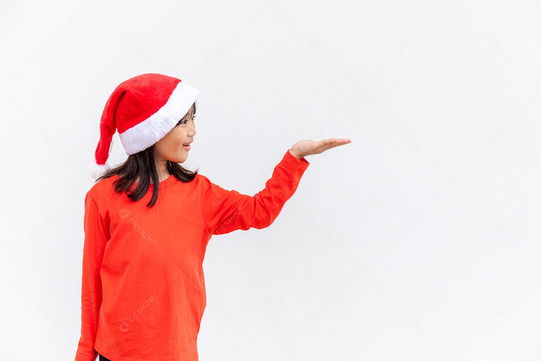 Menina asiática no chapéu de Papai Noel vermelho sobre fundo branco.