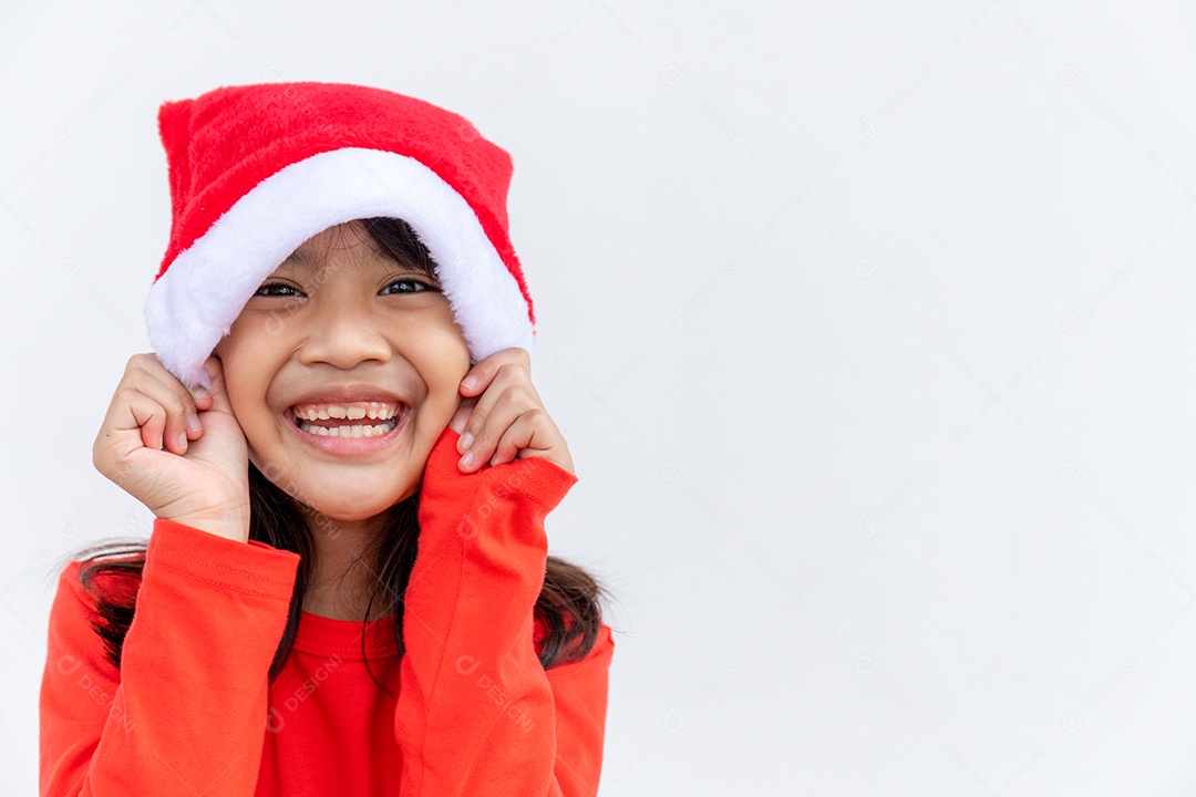 Menina asiática no chapéu de Papai Noel vermelho sobre fundo branco.