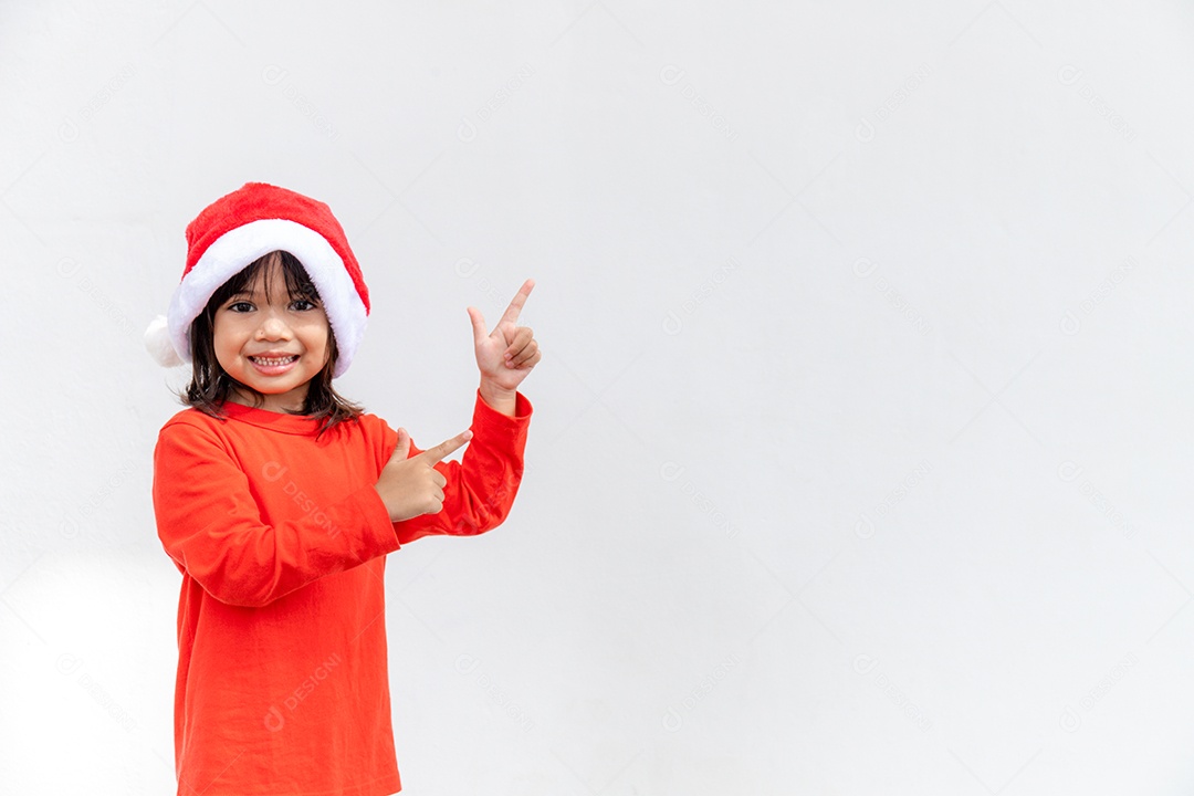 Menina asiática no chapéu de Papai Noel vermelho sobre fundo branco.