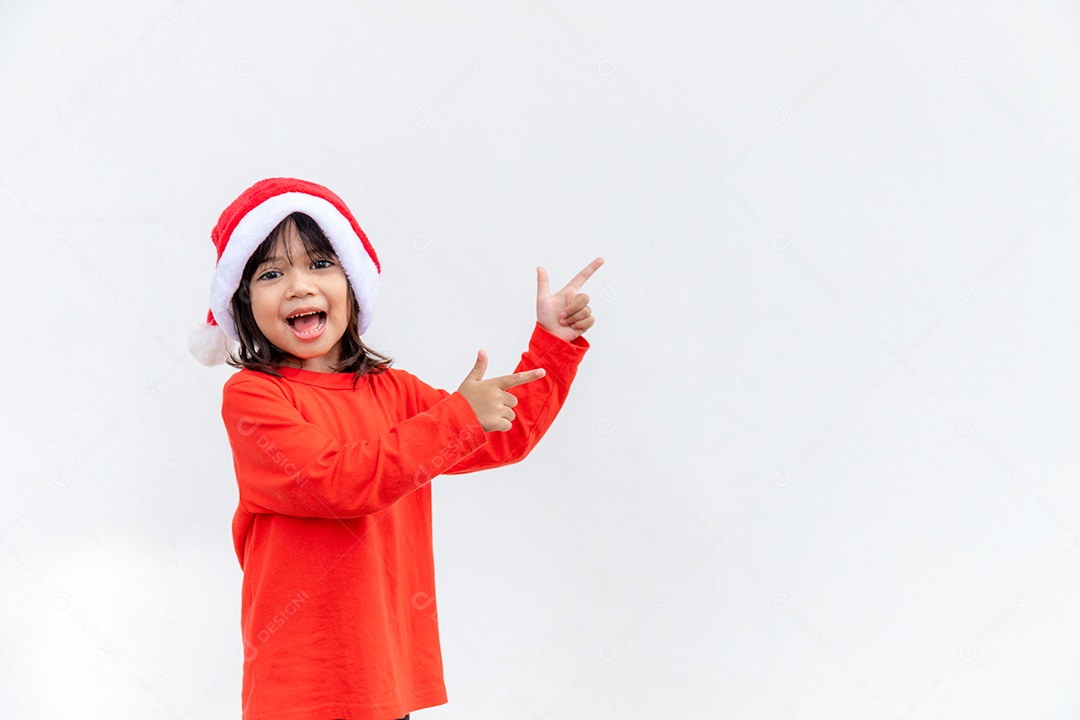 Menina asiática no chapéu de Papai Noel vermelho sobre fundo branco.