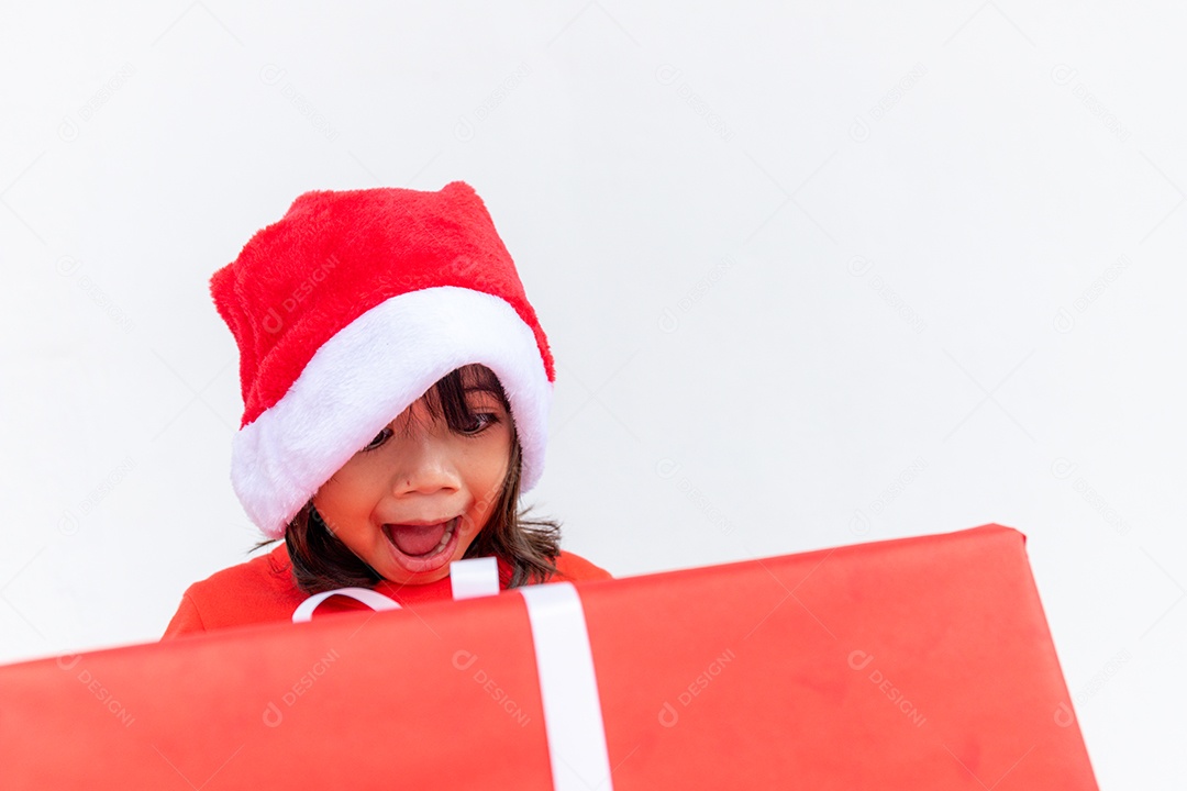 Feliz criança asiática no chapéu vermelho de Papai Noel segurando presentes de Natal