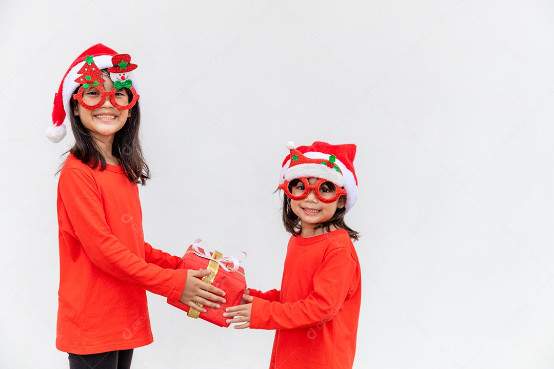 Irmãos asiáticos com chapéu de Papai Noel vermelho com caixas de presente