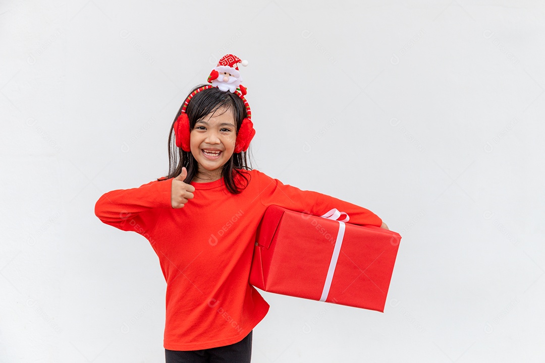 Feliz criança asiática no chapéu vermelho de Papai Noel segurando presentes de Natal