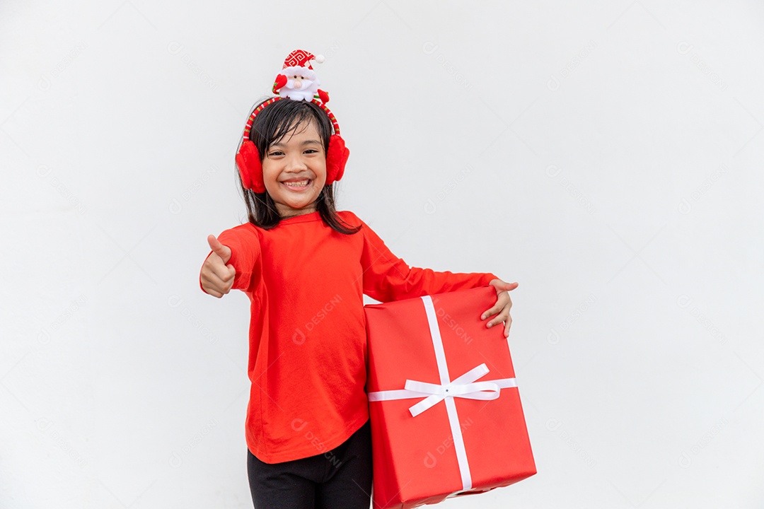 Feliz criança asiática no chapéu vermelho de Papai Noel segurando presentes de Natal.