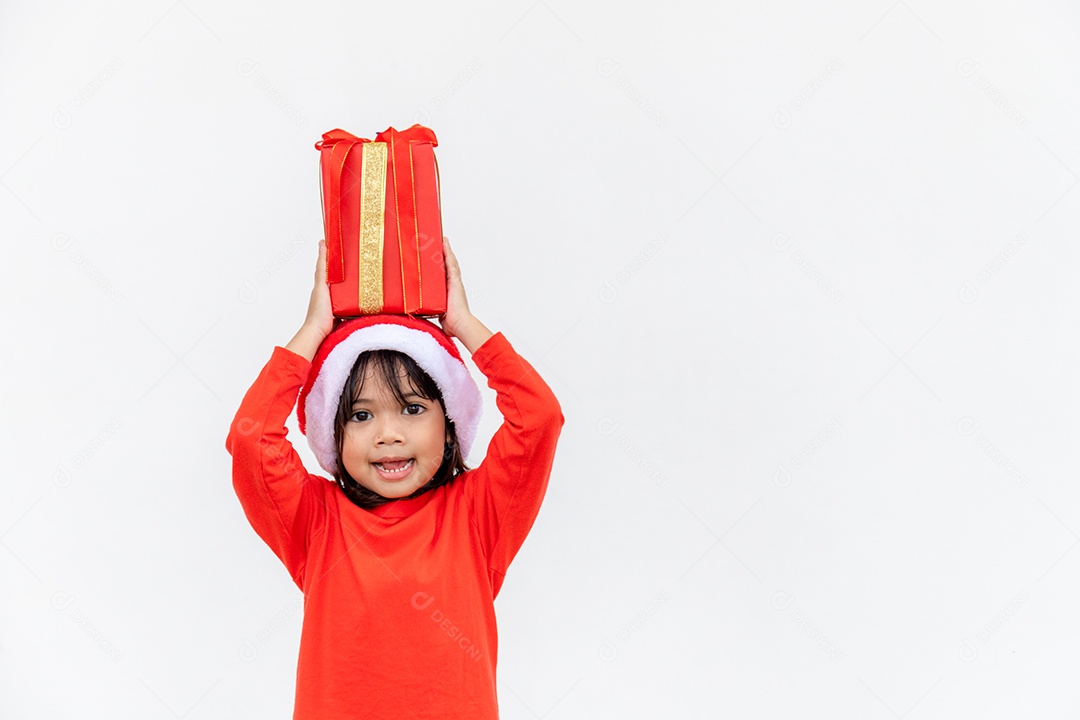 Feliz criança asiática no chapéu vermelho de Papai Noel segurando presentes de Natal