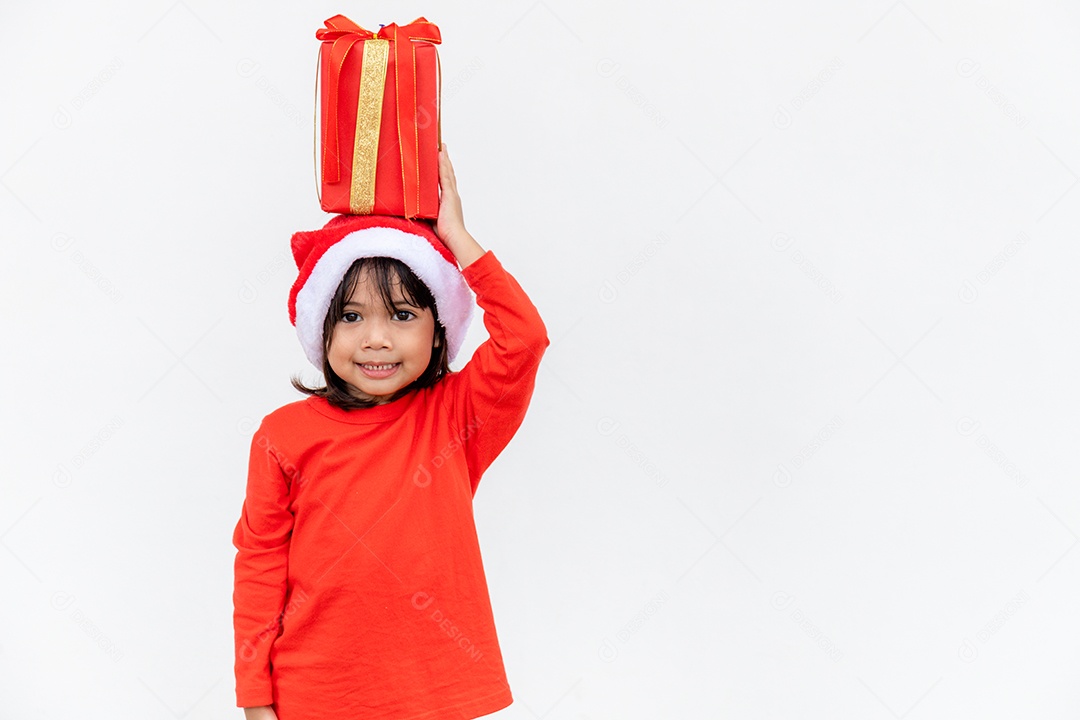 Feliz criança asiática no chapéu vermelho de Papai Noel segurando presentes de Natal.