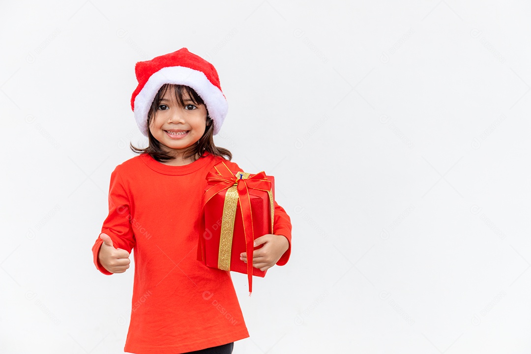 Feliz criança asiática no chapéu vermelho de Papai Noel segurando presentes de Natal.