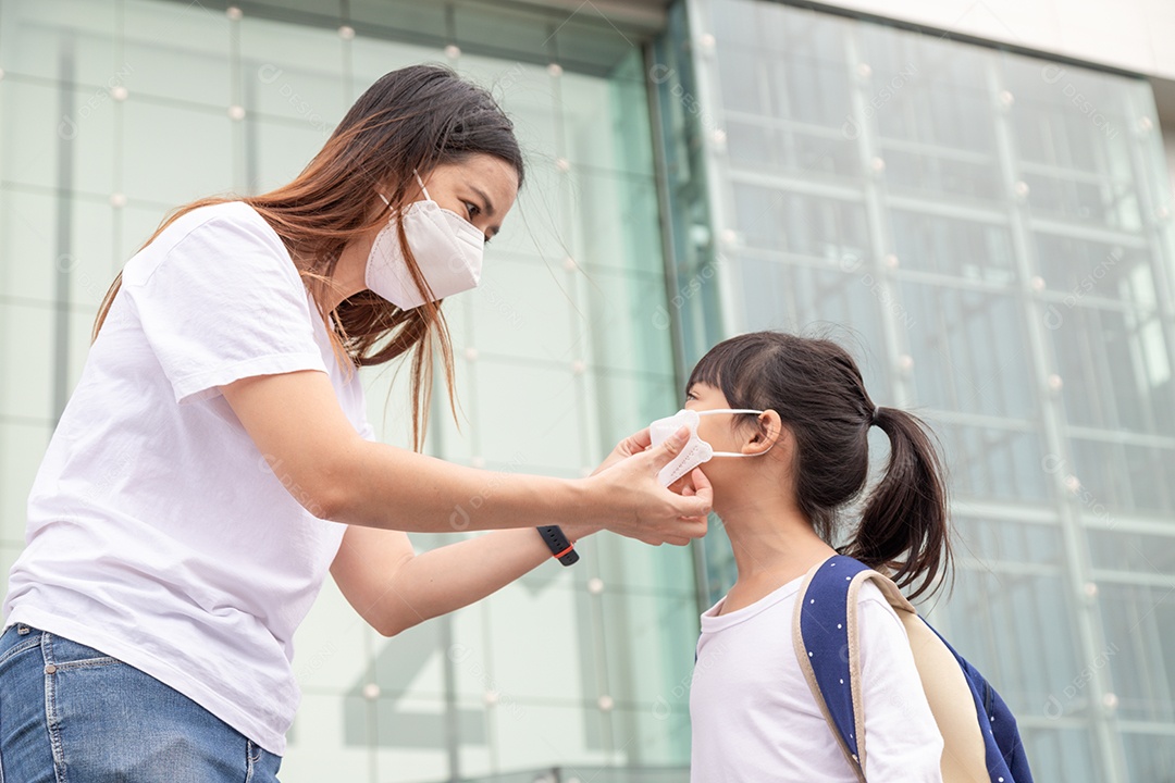 Família com crianças com máscara facial em um shopping center.
