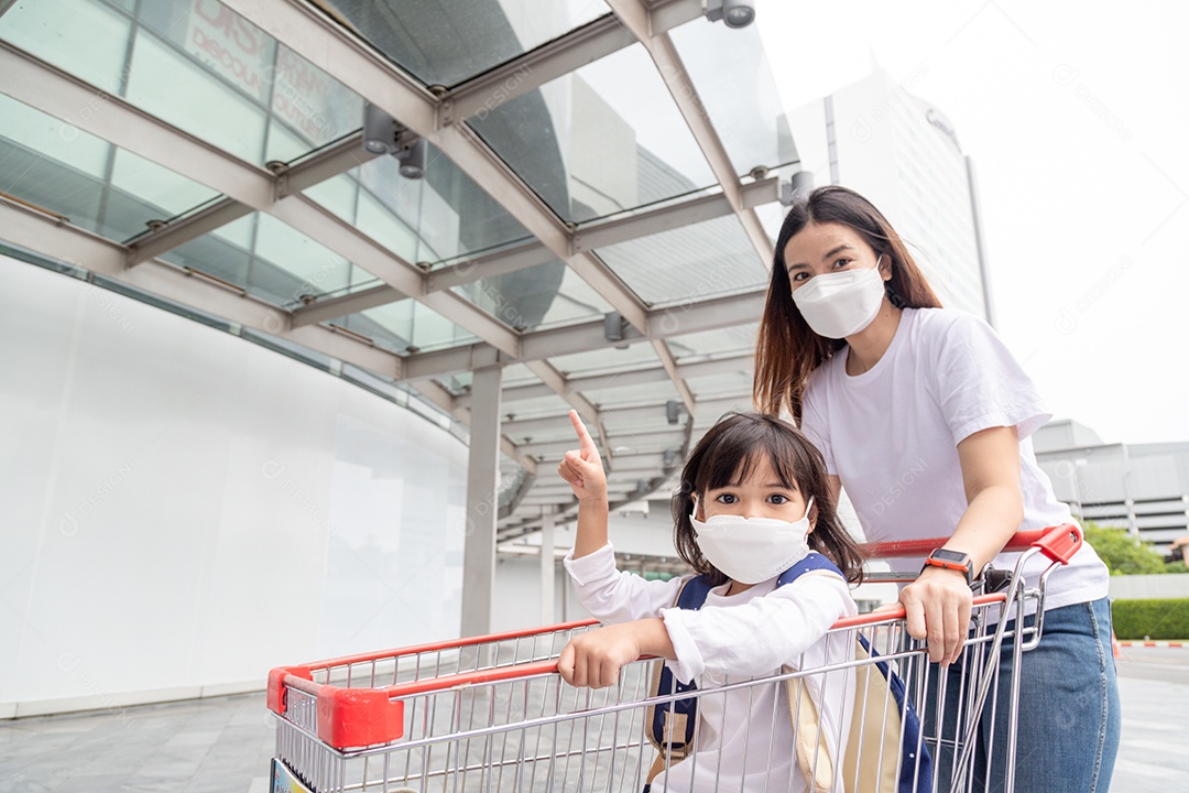 Compras com crianças durante um surto de vírus. Mãe asiática e dau