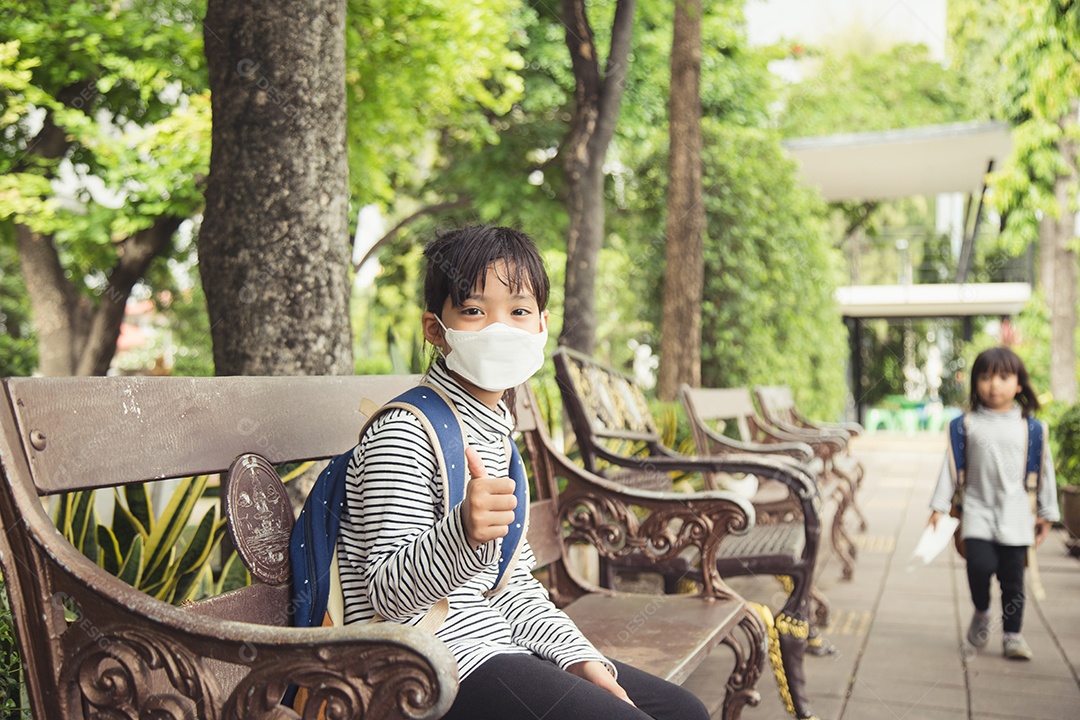 De volta à escola. Linda garota asiática com mochila e indo para a escola